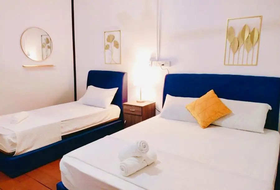 A relaxing bedroom at Bihing Angan Water Chalet featuring two large beds, modern style gold wall decor, a sleek mirror, smooth timber floors, and AC.