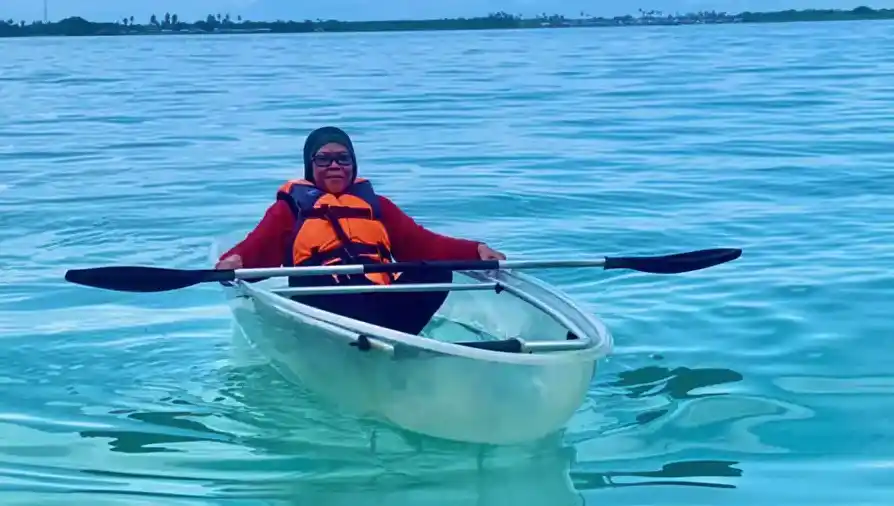 Guest enjoying sea kayaking in the calm lagoon Bihing Angan Water Chalet