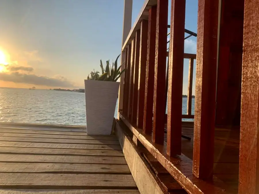 Private outdoor deck with sea views during golden hour at Bihing Angan Water Chalet.