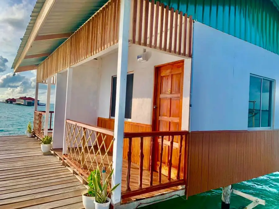 A standalone wooden chalet built in a local style with a turquoise corrugated metal roof and timber siding at Bihing Angan Water Chalet.